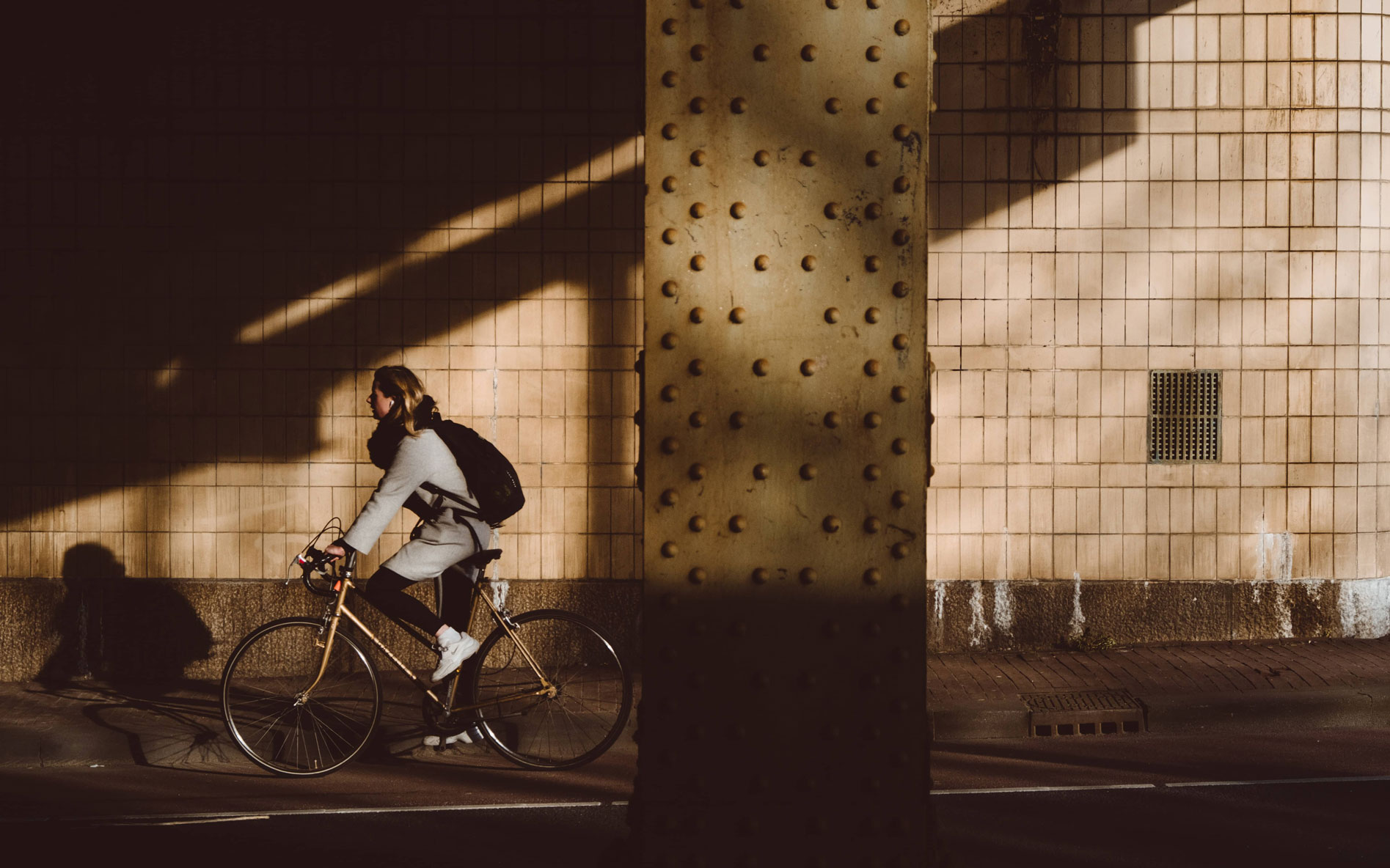 Frau auf Fahrrad unter einer Brücke