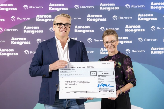 Harry Thomsen, CEO Aareon AG, überreicht den Spendenscheck an Petra Eggert-Höfel, Generalsekretärin DESWOS e.V. (Foto: Jochen Tack, Essen)