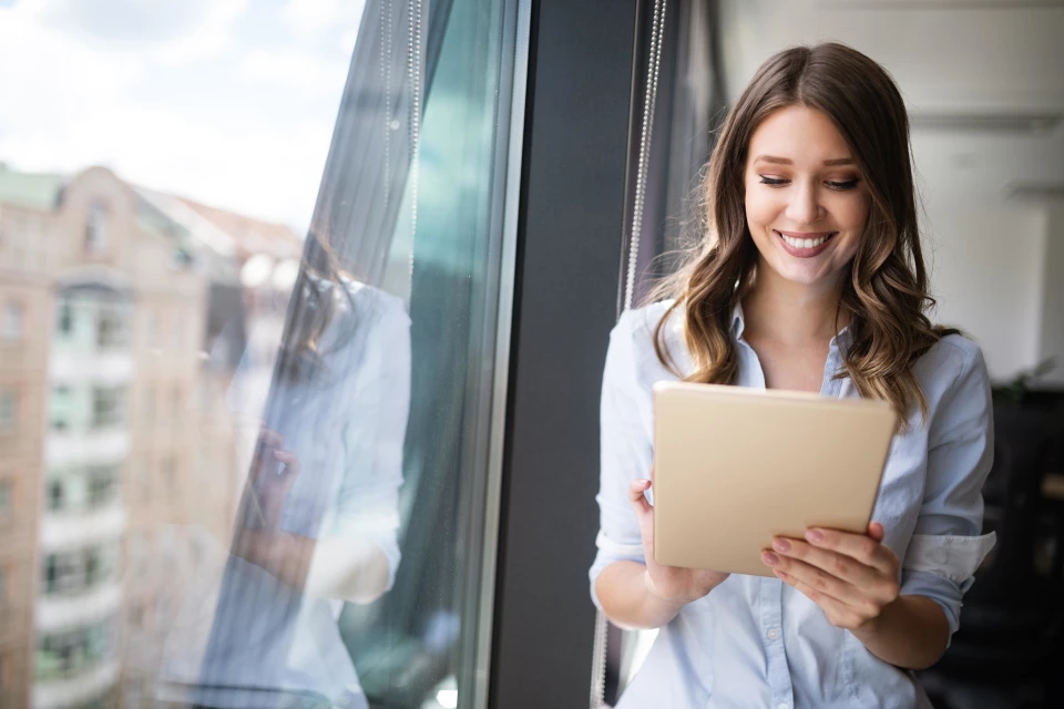 Frau mit Tablet am Fenster Frau mit Tablet am Fenster