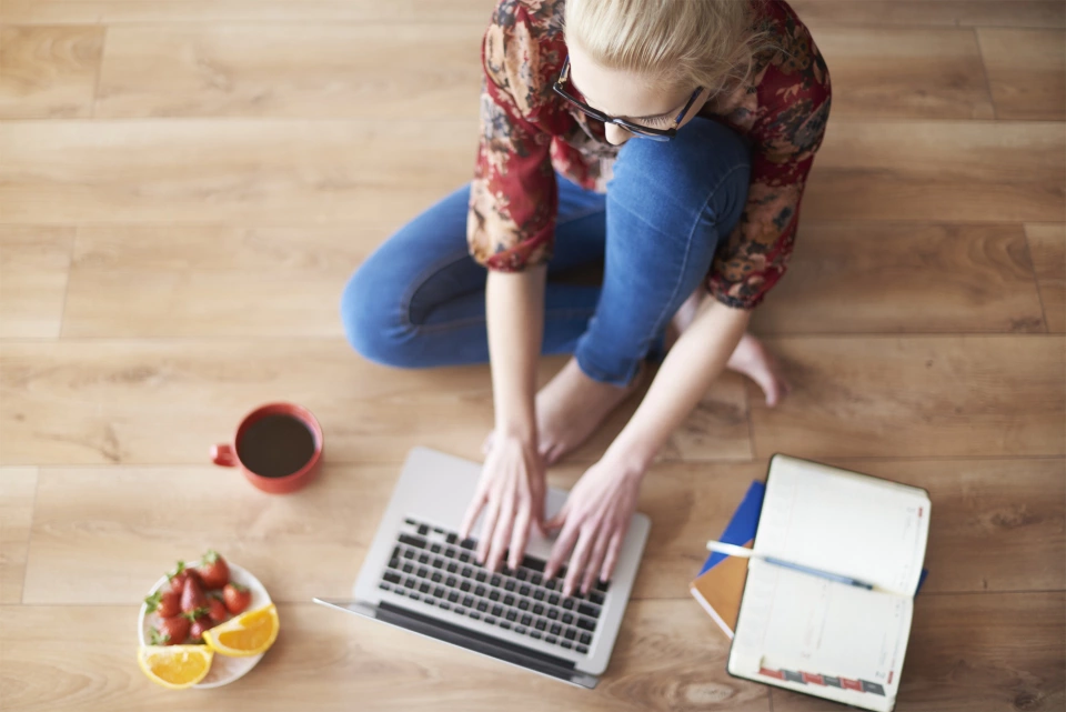 Frau am Boden mit Laptop