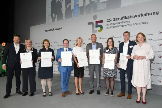 Gruppe von Menschen, die die Zertifikatsurkunde berufundfamilie in der Hand halten