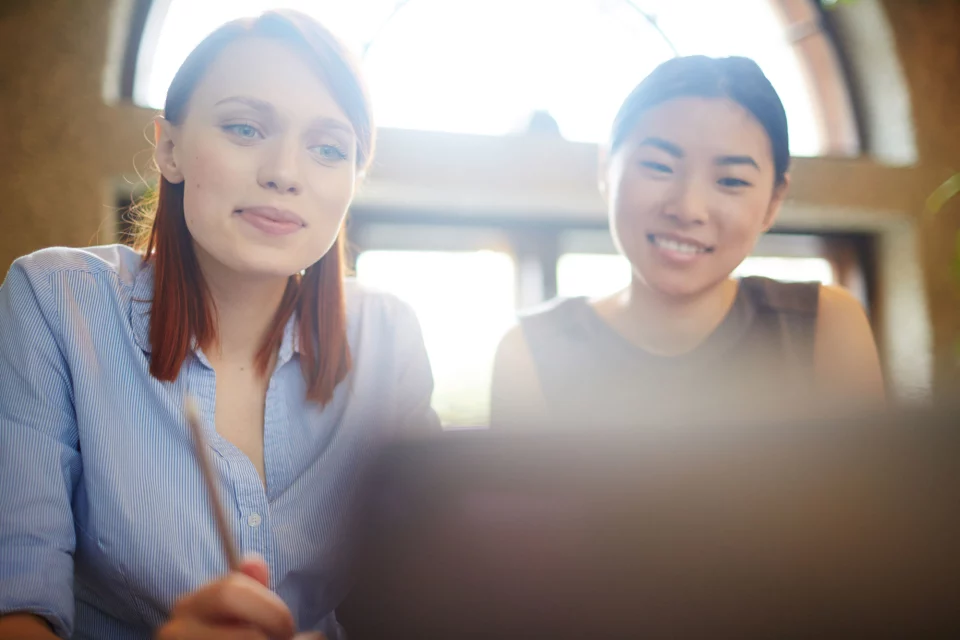 Zwei Frauen nehmen an einem Webinar teil.