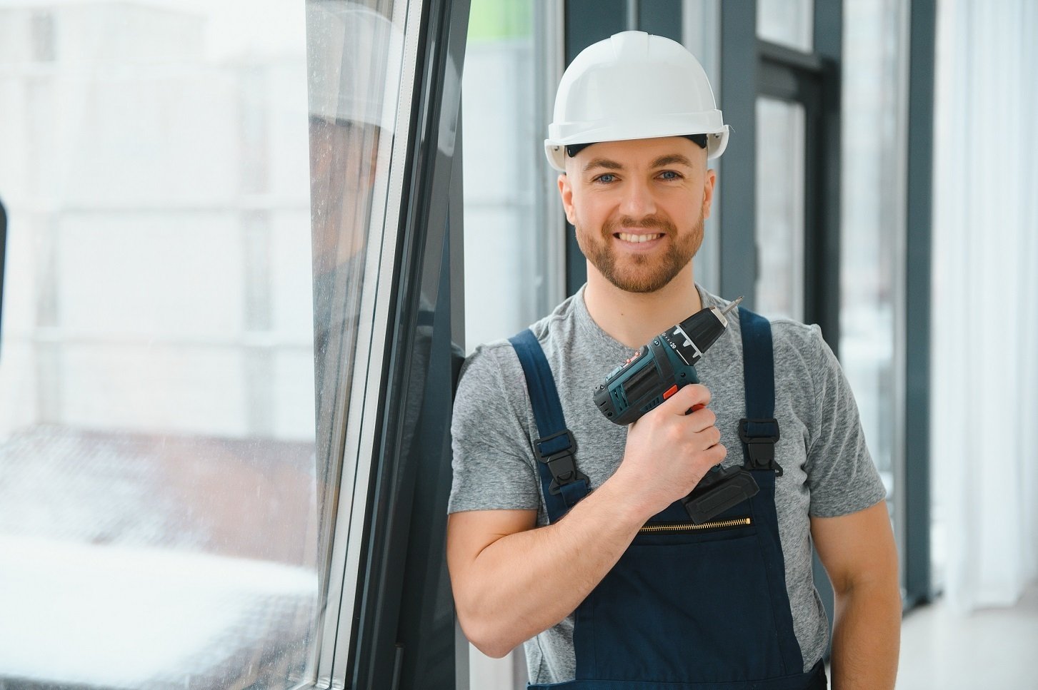 Handwerker mit Sicherheitshelm und Akkuschrauber