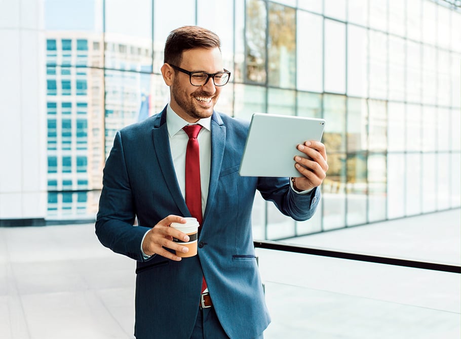 Mann mit Tablet und Tasse Kaffee in der Hand