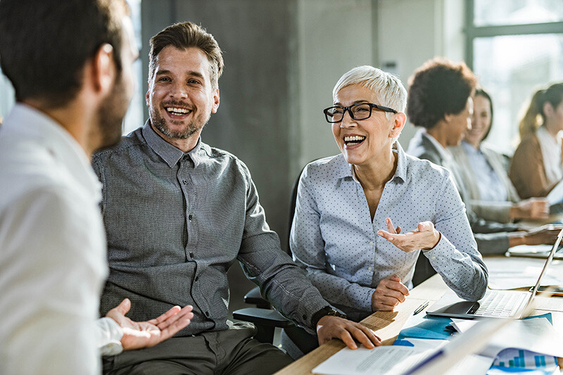 Fröhliche Kollegen bei der Besprechung