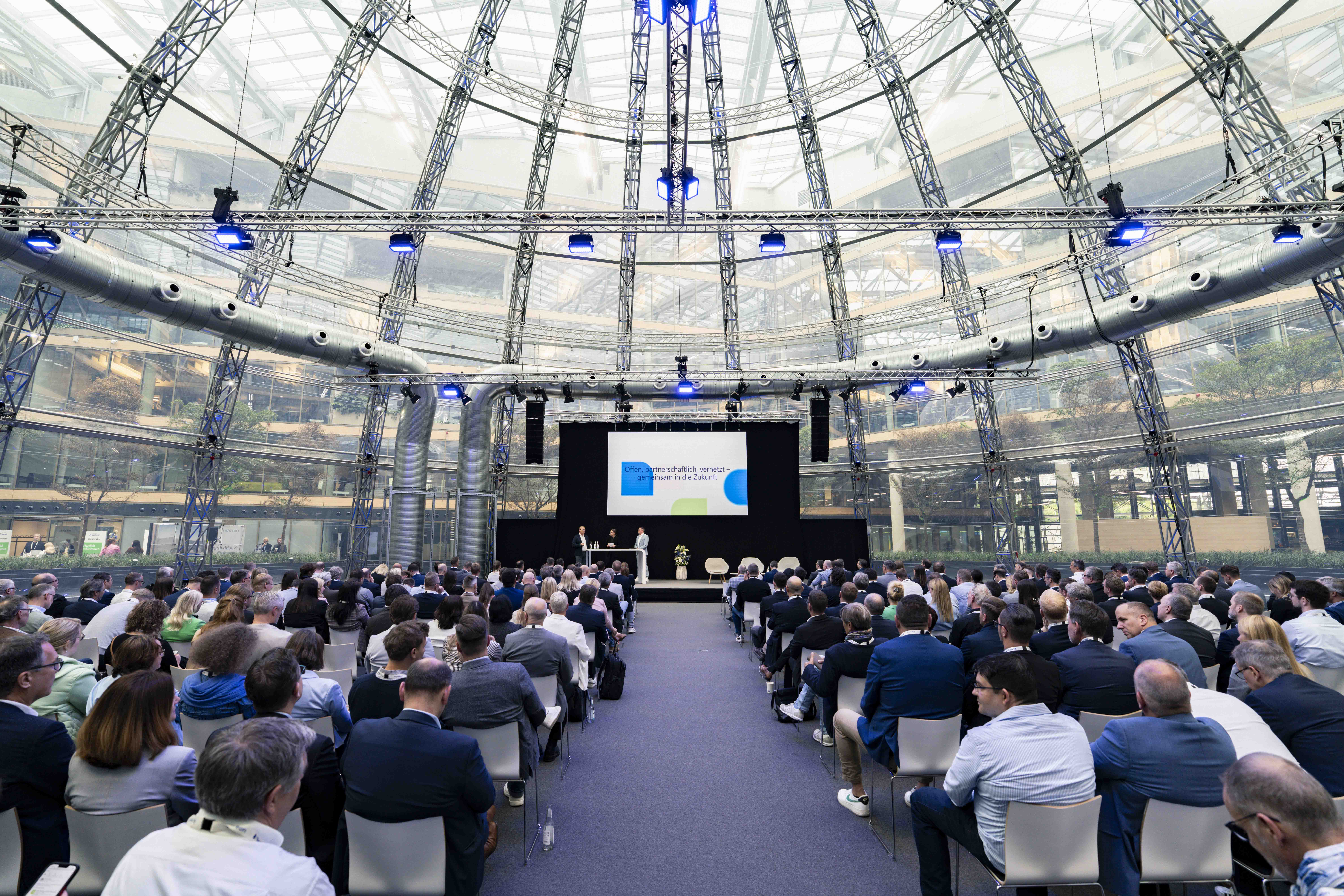 Menschen im Plenum hören einem Vortrag auf dem Aareon Summit 2025 zu